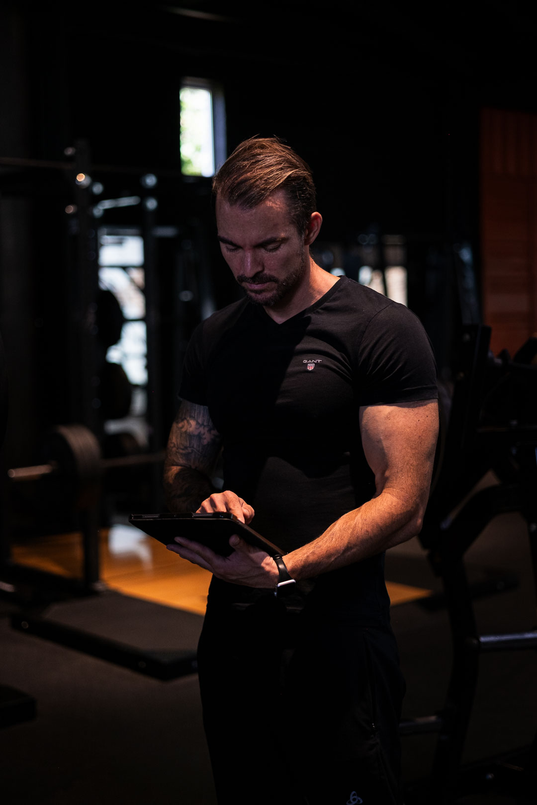 2026-08-29-Gerrit-Fitness-web_16 Abnehmcoach Gerrit Speidel mit Trainingsplan auf Tablet im Fitnessstudio