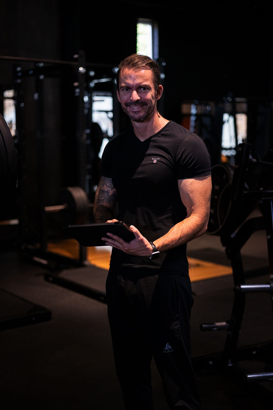 Abnehmcoach Gerrit Speidel mit Tablet im Fitnessstudio